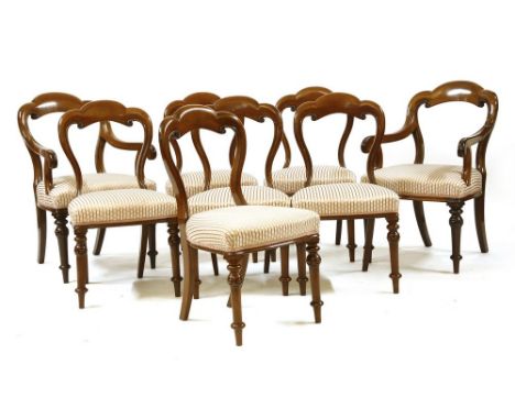 A set of eight mahogany dining chairs, with shaped, carved backs, over overstuffed upholstered seat and on ring turned taperi