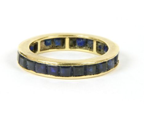 A sapphire flat section eternity ring, calibre cut sapphires channel set to a plain polished guards, one stone deficient, tes