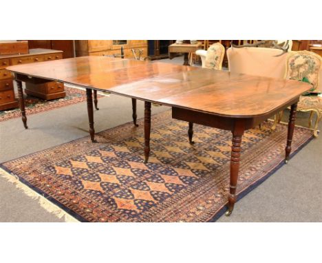 A mahogany D-End dining table, early 19th century and later, on a ring turned tapering legs and brass casters, complete with 