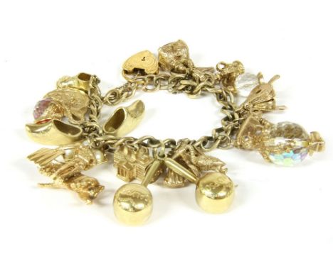 A 9ct gold curb link chain with padlock, and twenty assorted charms, to include a 9ct gold starfish, crown, cornelian plaque 