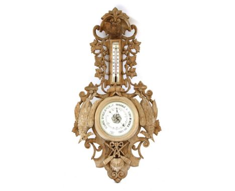 A late 19th century Blackforest style wall barometer, the case carved with a dog's head to the top, fruiting vines, game bird