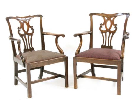 A pair of mahogany Chippendale style elbow chairs, the shaped top rail with stylised foliate carving over a pierced splat bac