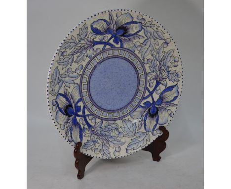 A Charlotte Rhead Bursley Ware pottery charger with tubelined floral and berry decoration in predominantly lilac colourway on