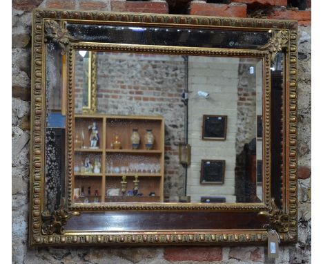 An antique giltwood and gesso framed cushion mirror, with bevelled plates, 97 cm x 82 cm high