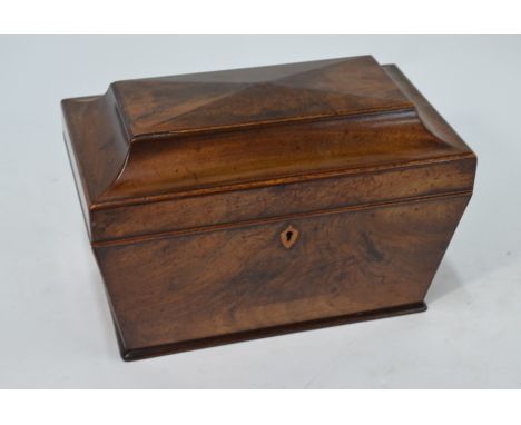 A Regency mahogany sacrophagus tea caddy, the interior with hinged cannisters flanking a circular well containing a cut glass