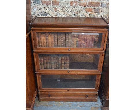 A vintage mahogany Globe Wernicke three glazed section library bookcase, raised on a full width base drawer