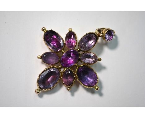 An antique amethyst pendant in the form of a cross, the eight oval foil backed amethysts radiating from a central oval amethy