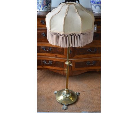 An Arts &amp; Crafts style brass telescopic standard lamp base raised on three cast paw feet