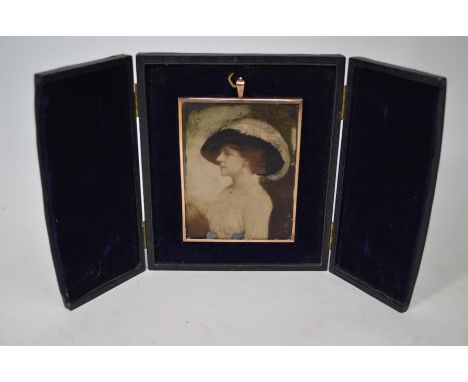 An Edwardian over-painted photographic portrait miniature of a lady in elegant clothing, in gilt frame and morocco-bound ease