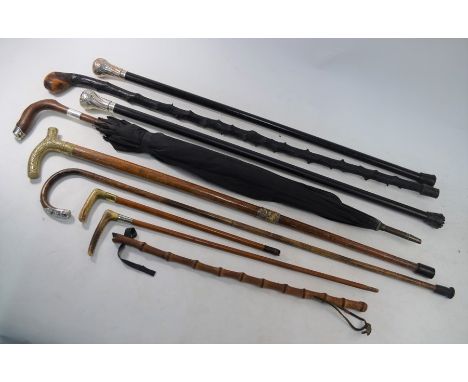 A silver mounted umbrella and walking stick, to/w various other walking sticks - some with metal mounts