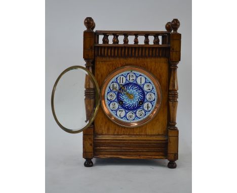 An Arts &amp; Crafts oak cased 8-day mantel clock, the Gothic style case with blue ceramic dial and gilt hands, the movement 
