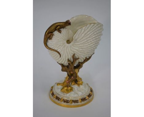 A Victorian Royal Worcester nautilus shell vase surmounted by a lizard, supported by a coral stump, seashells and rocks on a 