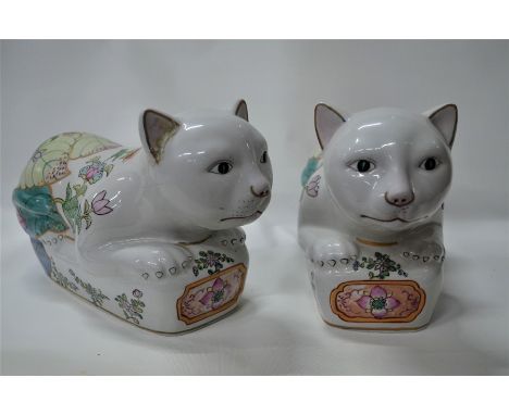 A companion pair of Chinese porcelain famille rose recumbent cats, 20th century, painted in gilt highlighted polychrome ename