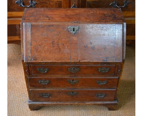 A rare 18th century child's elm bureau, the fall enclosing an arrangement of niches, over three long graduated drawers raised