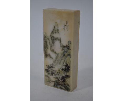A late Qing or Republic period Chinese white marble scroll weight of rectangular form painted with pine trees in a mountainou