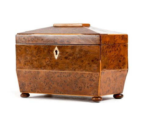 A Regency burr yew tea caddy, of sarcophagus shape, inlaid with boxwood stringing, the interior with twin lidded compartments