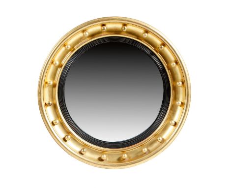 A Regency style giltwood convex wall mirror, with a reeded ebonised slip and a ball decorated frame, late 19th / early 20th c