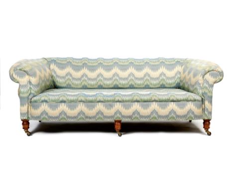 A late Victorian walnut Chesterfield sofa, upholstered with Bargello style fabric, on ring turned front legs and on ceramic c