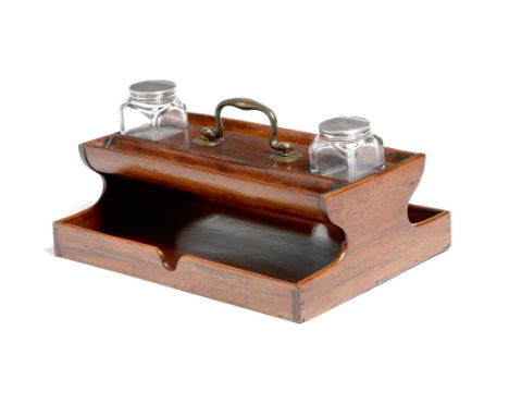 An early 19th century mahogany inkstand, with a brass handle, a pair of pen trays and two glass inkwells with silver lids, ea