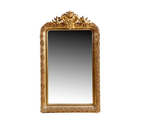 A French gilt and composition wall mirror, with an arched plate within a beaded slip, a leaf scroll outer border and with a c