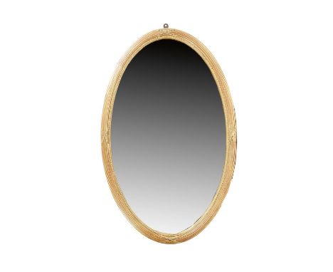 An oval giltwood wall mirror in George III style, the bevelled plate within a beaded and reeded frame, late 19th century, 84.