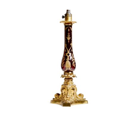 An early Victorian ormolu table lamp by Palmer & Co., later converted from an oil lamp, with a ruby glass baluster stem with 