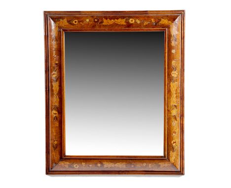 A walnut and marquetry wall mirror, the rectangular plate within a cushion frame inlaid with leaves and flowers, with a mould