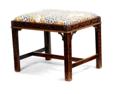 A mahogany Chinese Chippendale style stool, with a drop-in seat on blind fret carved chamfered legs united by an 'H' stretche