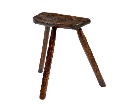 A primitive elm dairy stool, the underside of the seat branded with initials 'NB', on tripod supports, 53.4cm high, 59.7cm wi