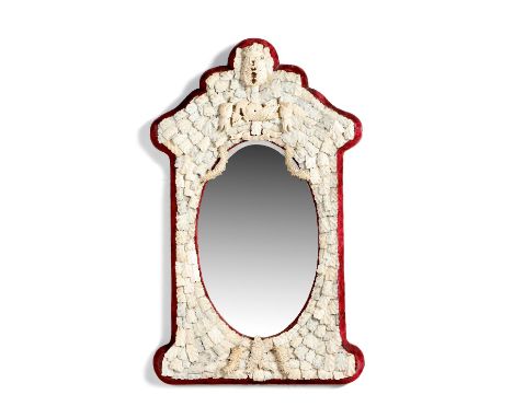 λ A late 19th century French Dieppe carved ivory and bone wall mirror, with a bevelled oval plate within a feathered leaf fra