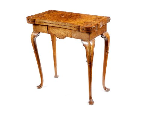 An early 18th century walnut and seaweed marquetry card table, the crossbanded fold-over top inlaid with stringing and burr p