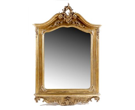 A Louis XV style giltwood wall mirror, the shaped plate within a moulded frame decorated with scrolls, leaves and rocaille, 1
