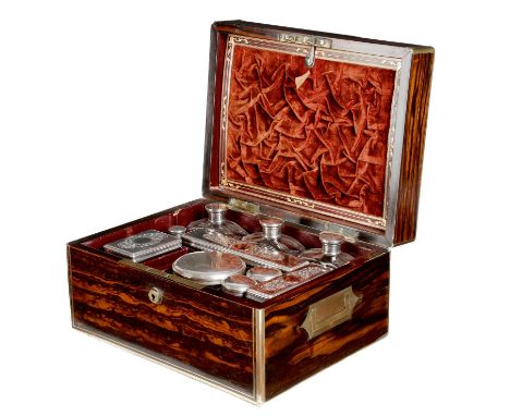 A Victorian coromandel and brass mounted dressing case, the underside of the lid with a letter pouch, above an arrangement of