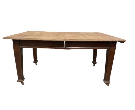 19th century oak dining table, the rectangular top raised on square tapering supports terminating in ceramic castors 