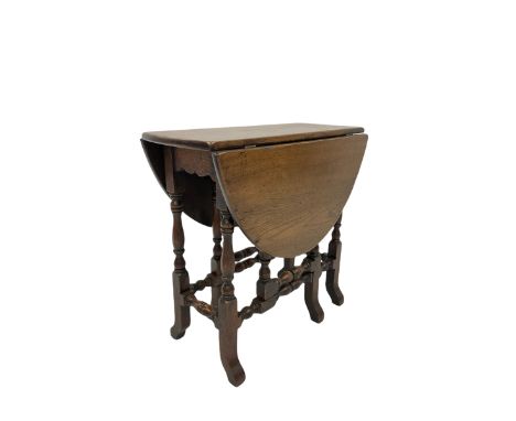 Oak gate leg table, the oval top over gate leg action, raised on turned and block supports 