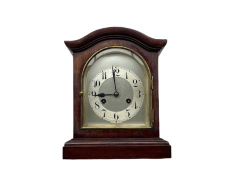 A Juhngans eight-day mantle clock in a mahogany case with a serpentine top striking the hours and half hours on a coiled gong