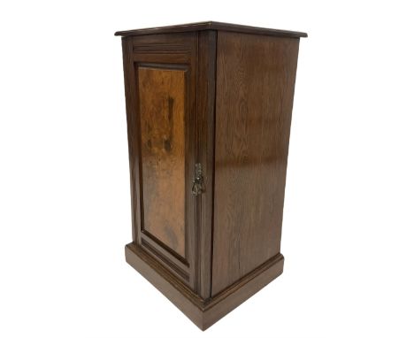 Early 20th century oak bedside cupboard, single fielded figured oak panelled door enclosing shelf, raised on plinth base 