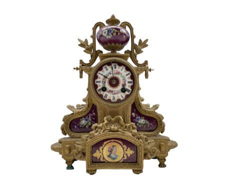 A late-19th century French mantle clock in a gilt spelter case surmounted with a hand painted porcelain urn decorated with ga