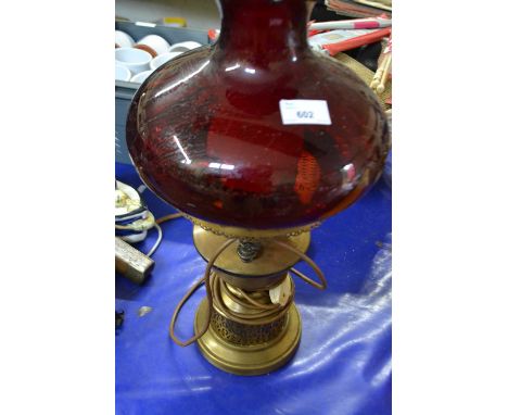 A Cranberry glass and brass oil lamp converted for electricity