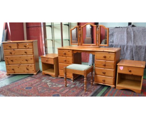 A pine bedroom suite comprising stool, dressing table, triptych mirror, eight drawers, a serpentine four drawer chest, two be