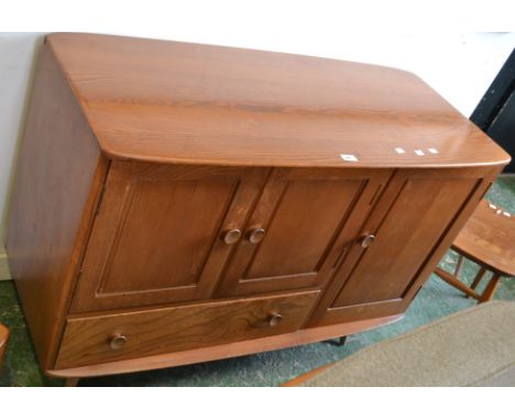 An Ercol style sideboard, two fielded panel door cupboard over long drawer, adjacent deep cupboard to base 