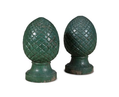A PAIR OF CAST IRON PINEAPPLE GARDEN FINIALS, painted dark green. 49cm high