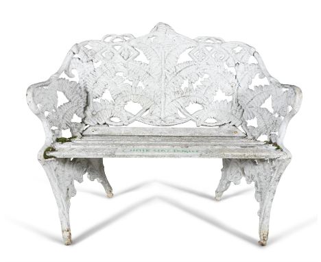 A WHITE PAINTED CAST IRON GARDEN SEAT, of compact two-seater proportion with fern pattern back and sides and slatted timber s