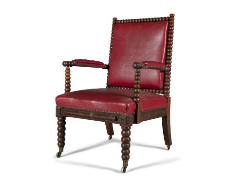 AN IRISH 19TH CENTURY BOBBIN TURNED WALNUT ARMCHAIR, in the manner of Strahan, upholstered in red hide, on tapering bobbin tu