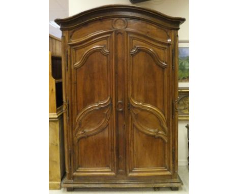 A late 18th / early 19th Century French walnut armoire, the arch cornice above a roundel with an inlaid five-point star, abov