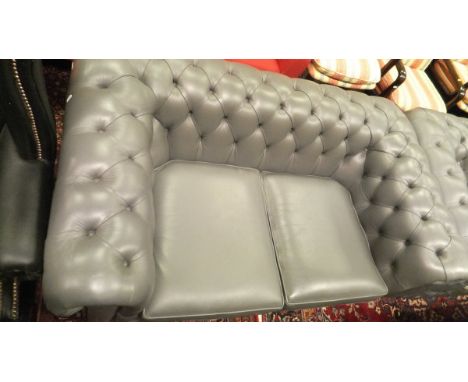 Two modern two-seat Chesterfield sofas in light grey leatherette upholstery, together with a similar footstool