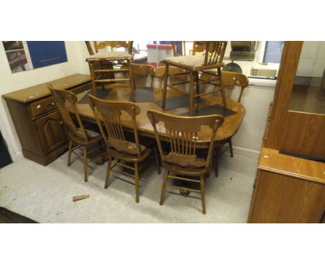 A 20th Century oak extending D end dining table and eight stick back chairs (6 plus 2), together with a matching oak sideboar