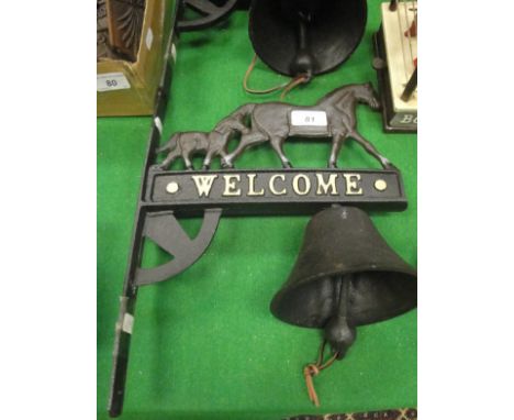 A cast iron bell mounted on a cast iron wall bracket decorated with horses and inscribed "Welcome", together with a cast iron