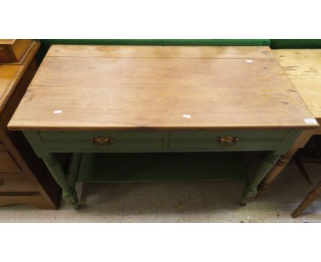 An Edwardian side table, the rectangular pine top above a green painted base of two drawers raised on turned and ringed legs 