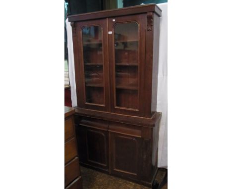 Victorian stained walnut library bookcase, the top section enclosed by pair glazed panel doors, two drawers and cupboard belo